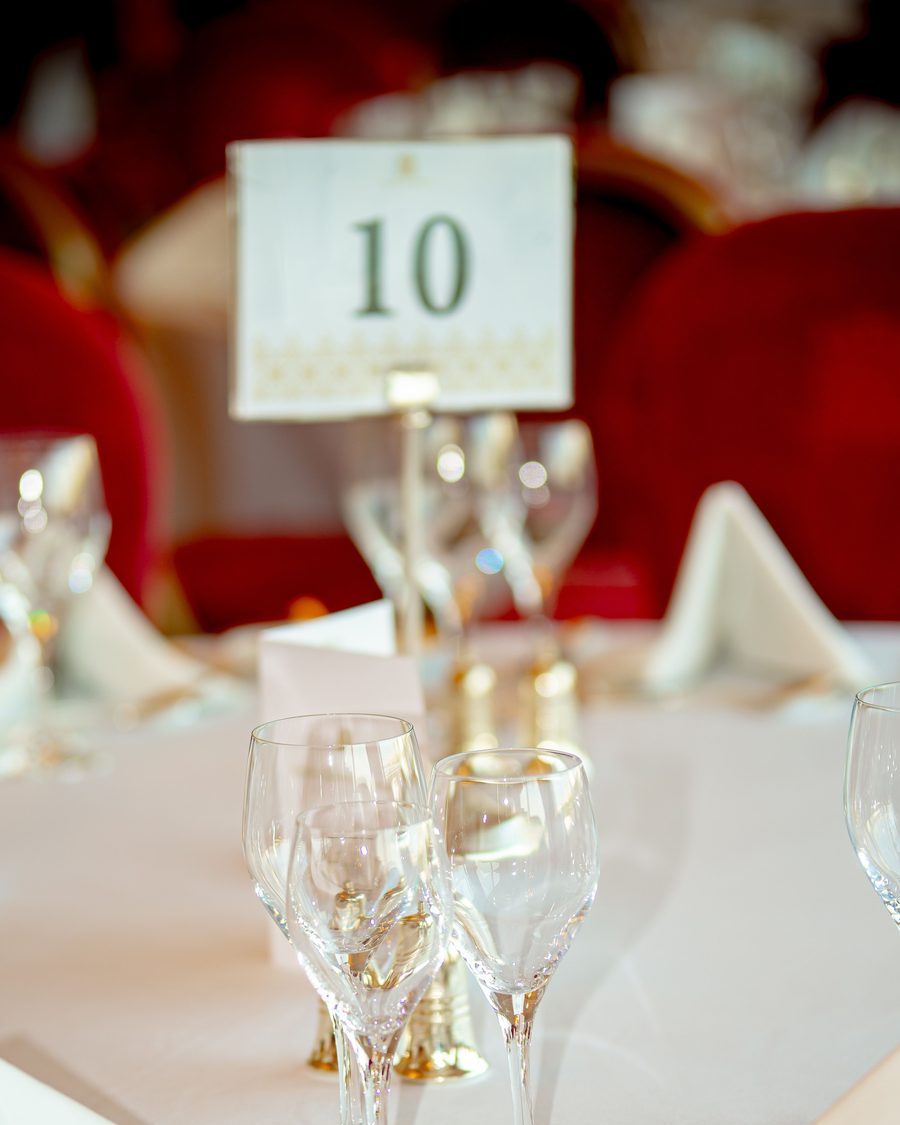 Banquet table setting with a numbered table card and crystal glassware