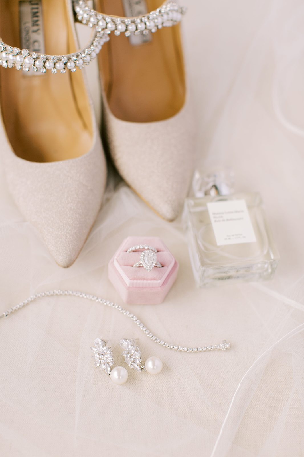 Bridal shoes, clutch, and perfume flatlay