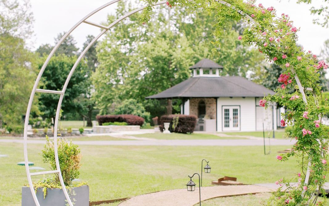 Garden path leading to a floral moon arch with lanterns