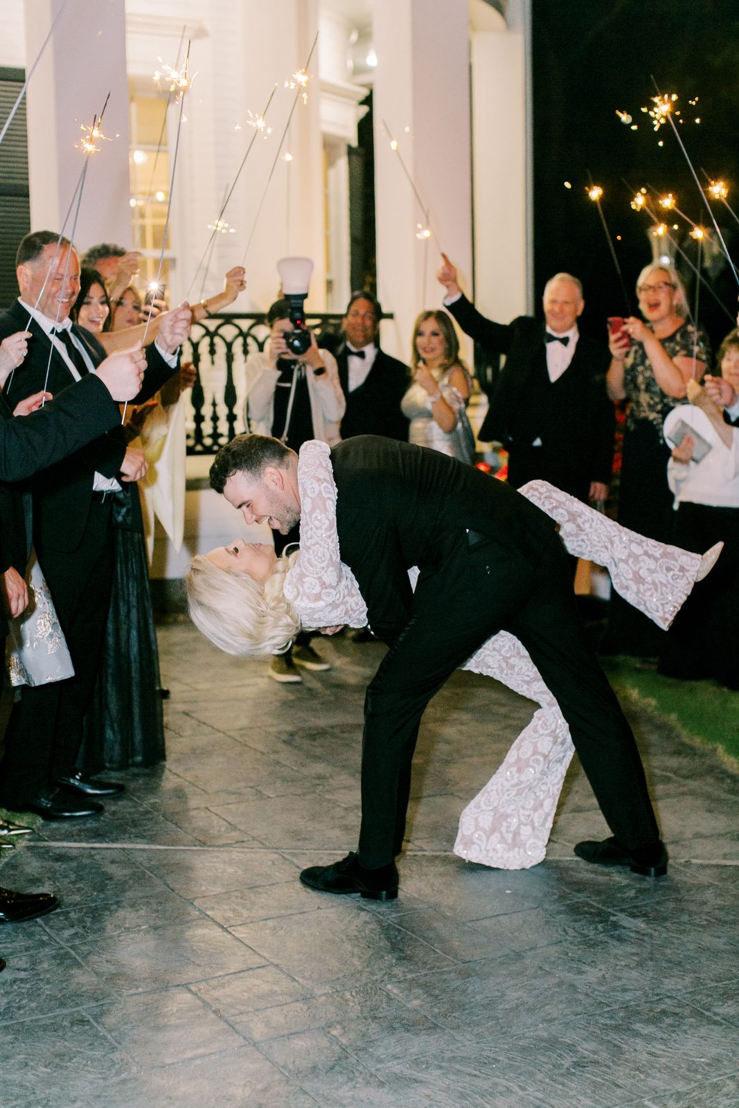 Brian dipping Alexa for a kiss during their sparkler exit