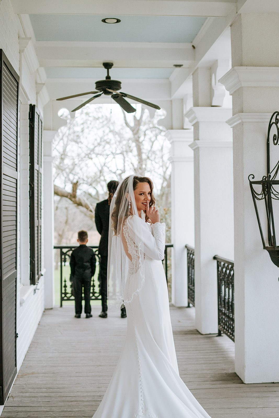 Alyssa on the porch with Eniola and their ring bearer in the background
