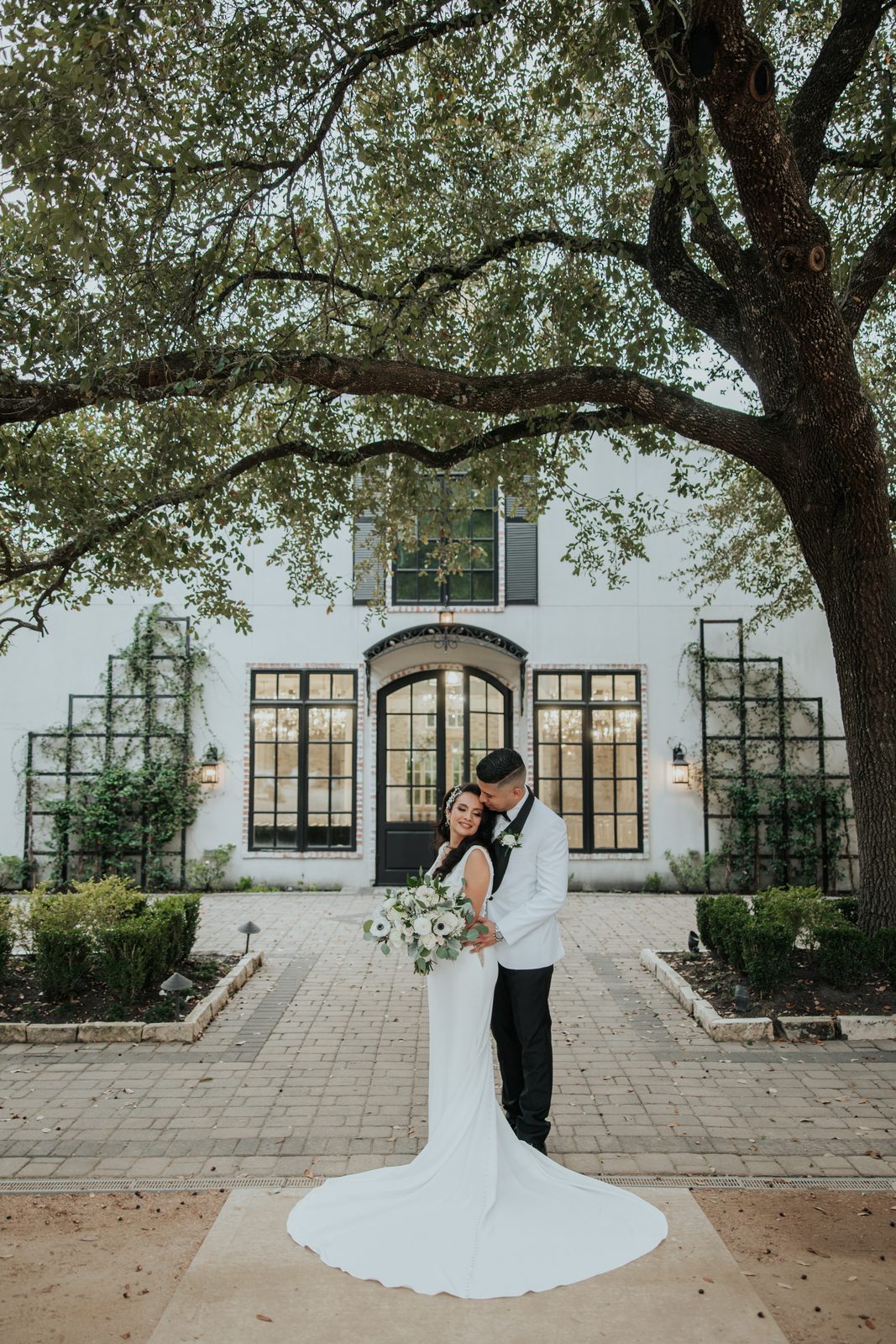Amber and Walter portrait under a tree in front of the venue