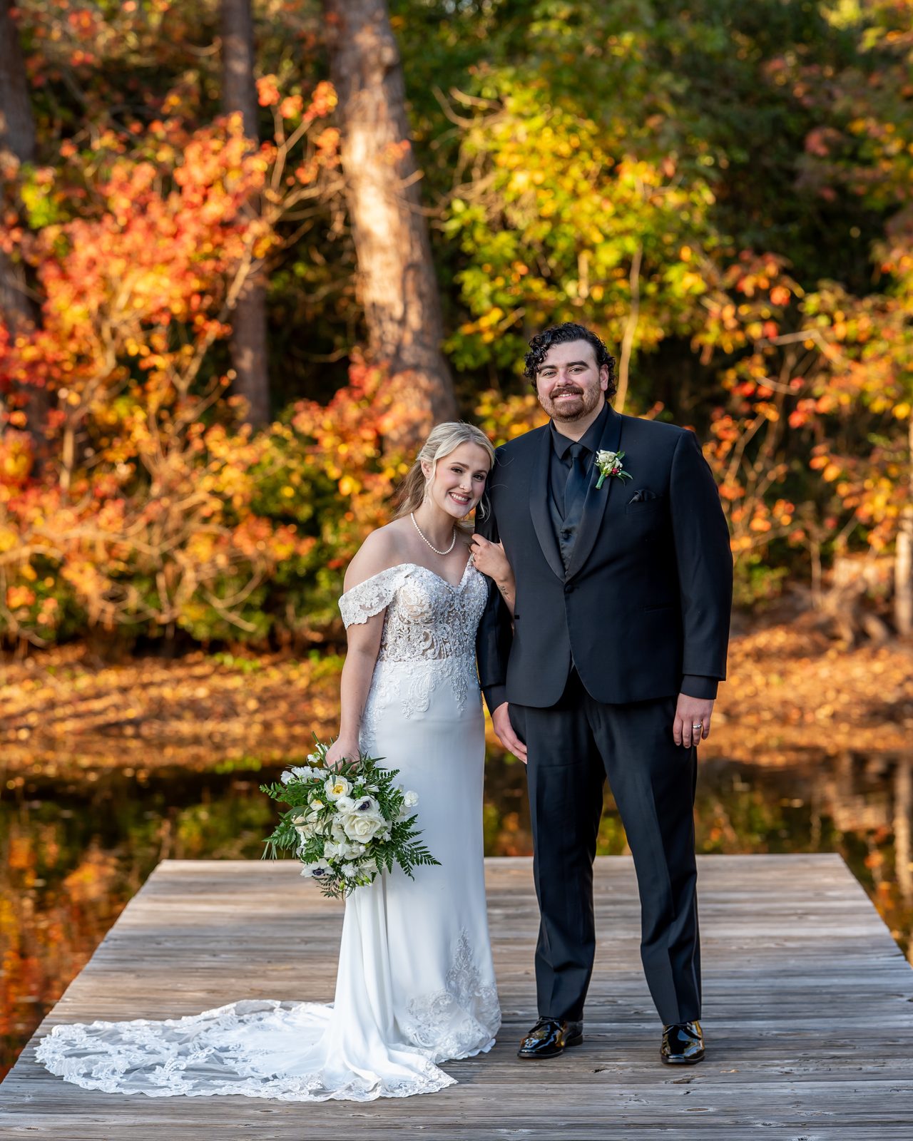 Chris and Bailey portrait on the dock in fall foliage