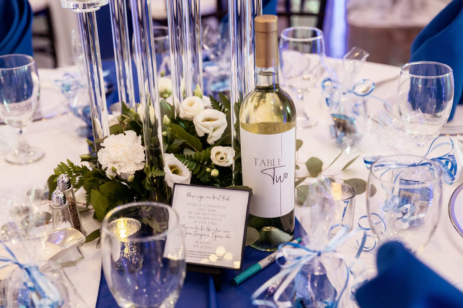 Reception centerpiece with a sign-the-wine-bottle guestbook