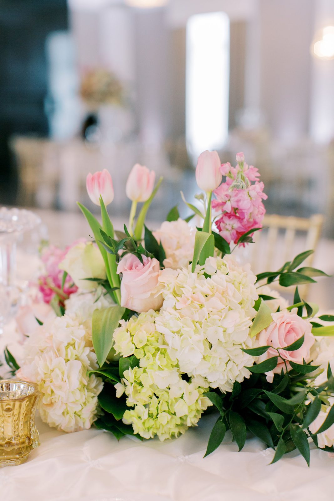 Tall trumpet-vase centerpiece with blush and white florals