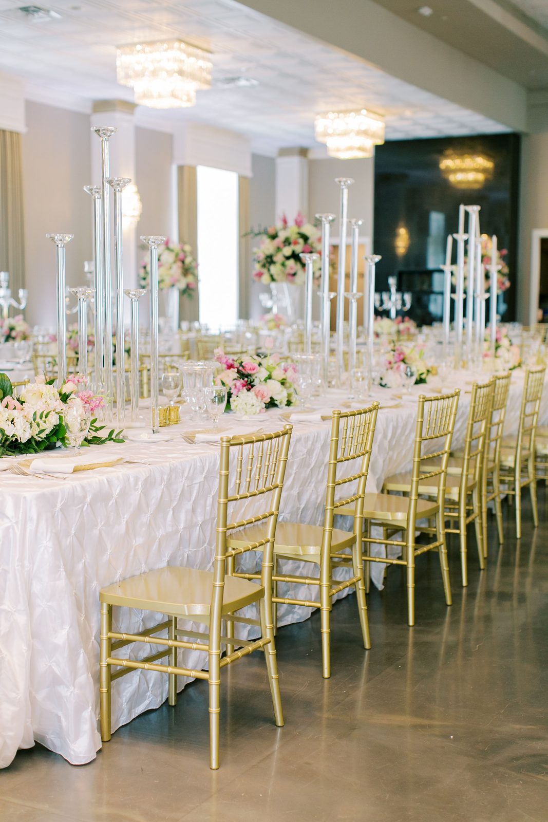 Long reception table with tall crystal candlesticks and gold chiavari chairs