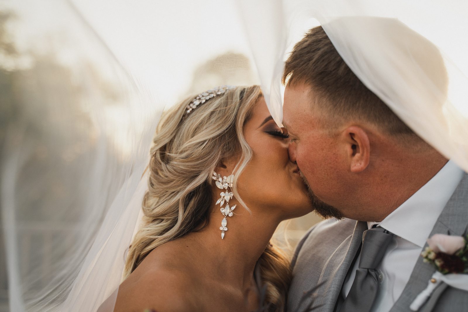 Erica and Tyler kissing under her veil