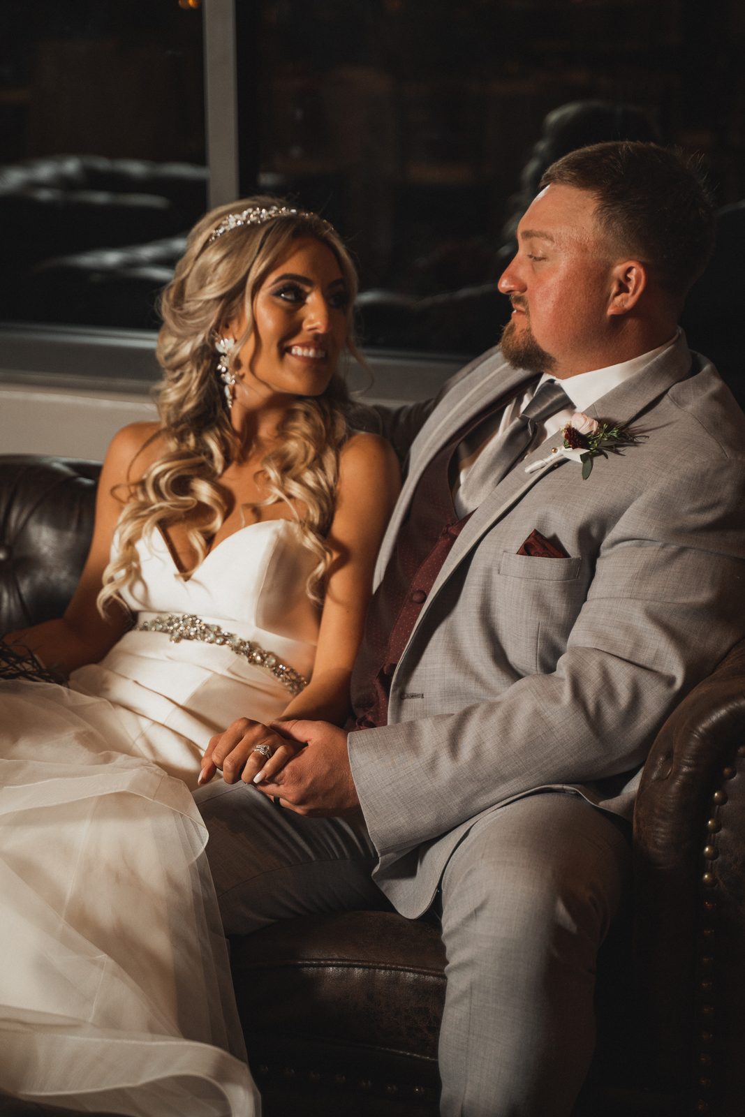 Erica and Tyler seated together on a leather couch
