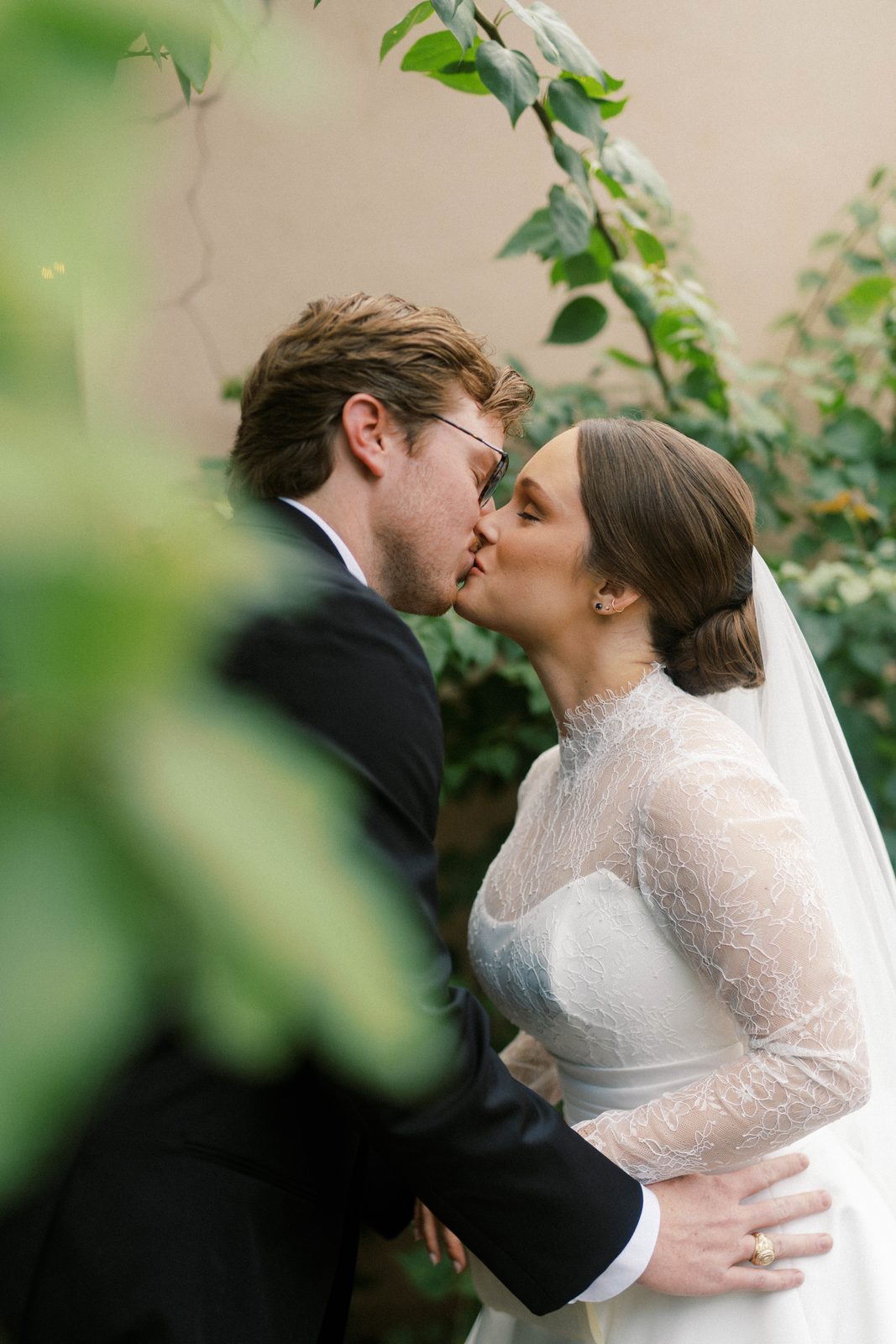 Madison and Tanner kissing amid greenery