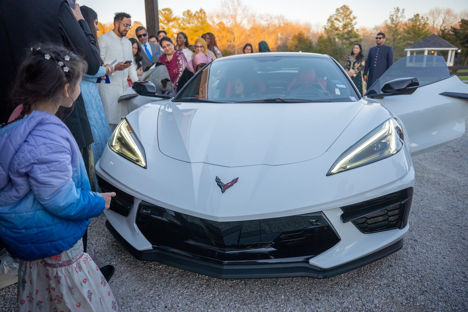 Guests gathered around the couple's white Corvette send-off car