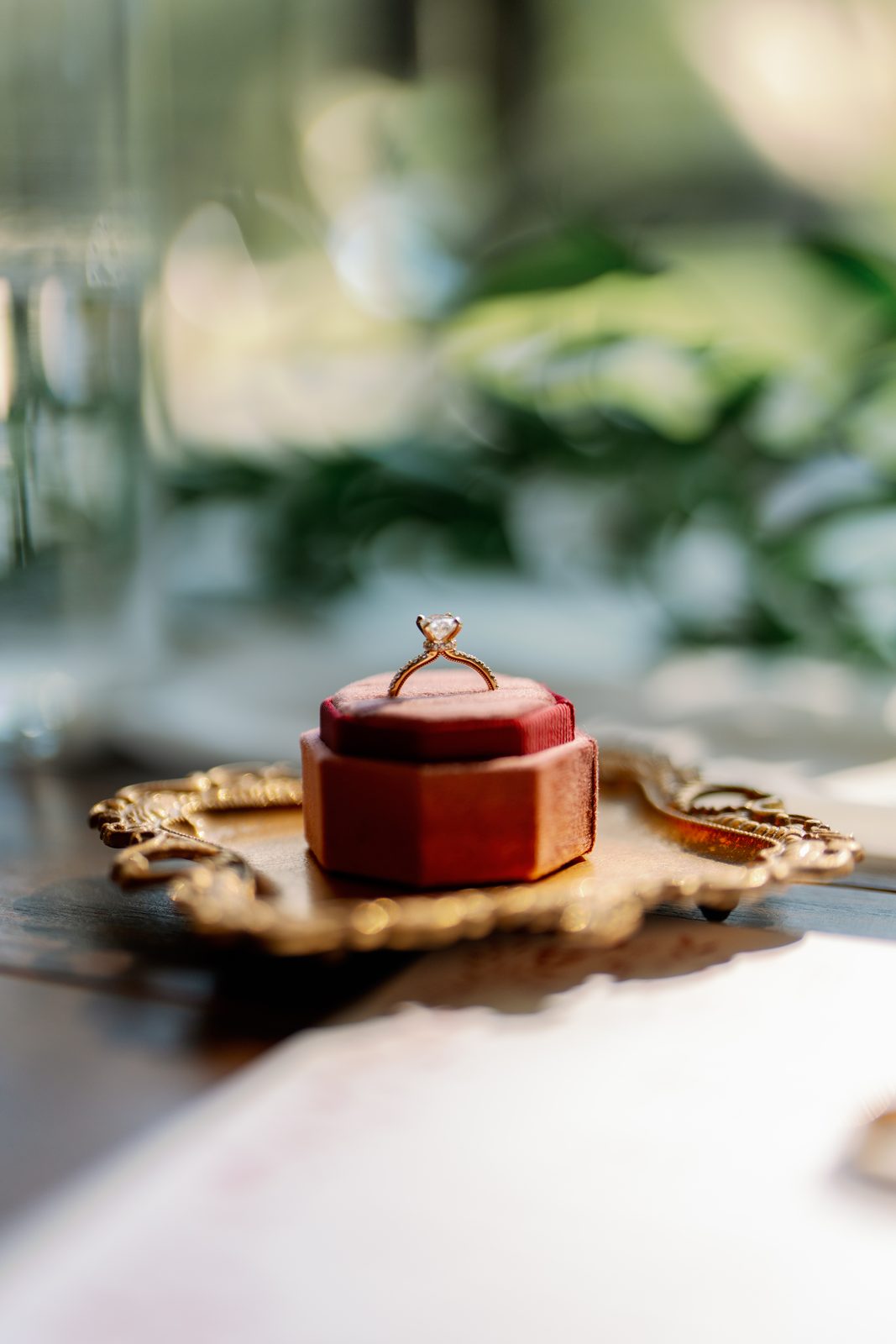 Engagement ring detail on a velvet box and gold tray