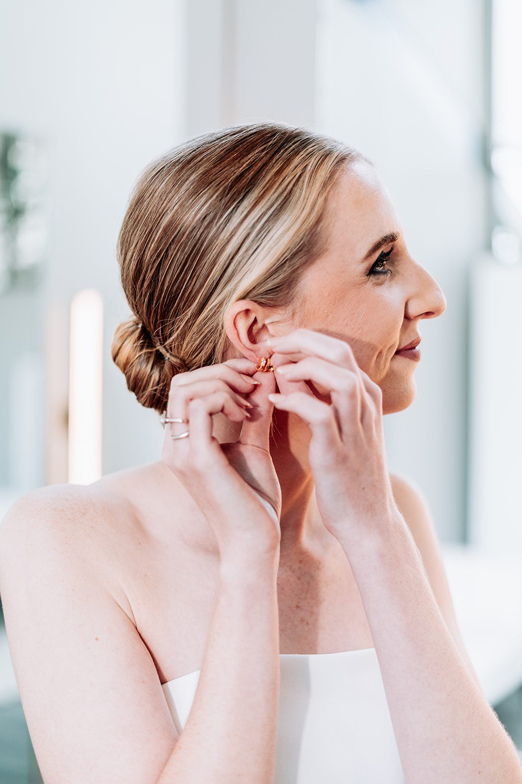 Sara putting on her earring while getting ready