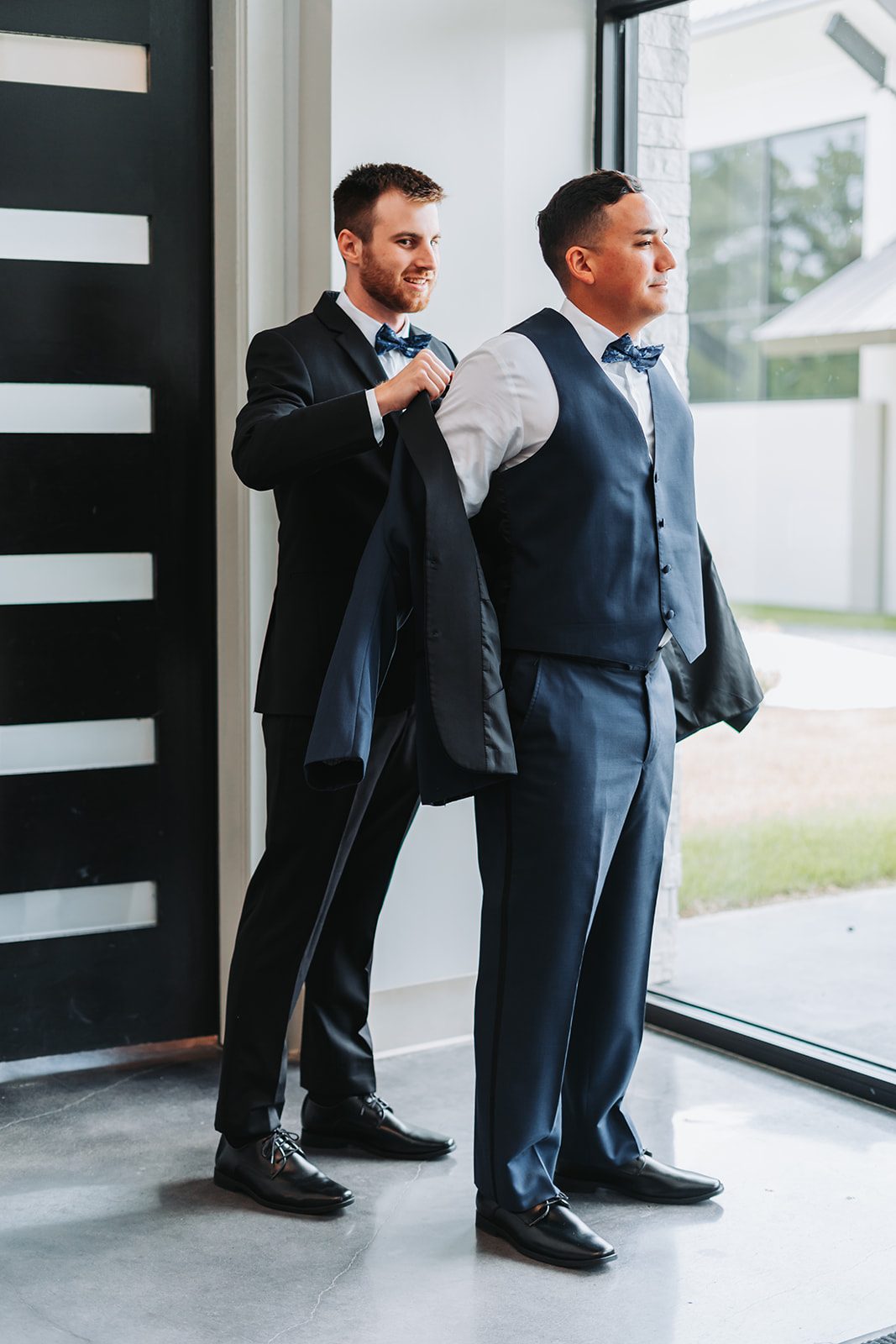 Groomsman helping Gus into his jacket
