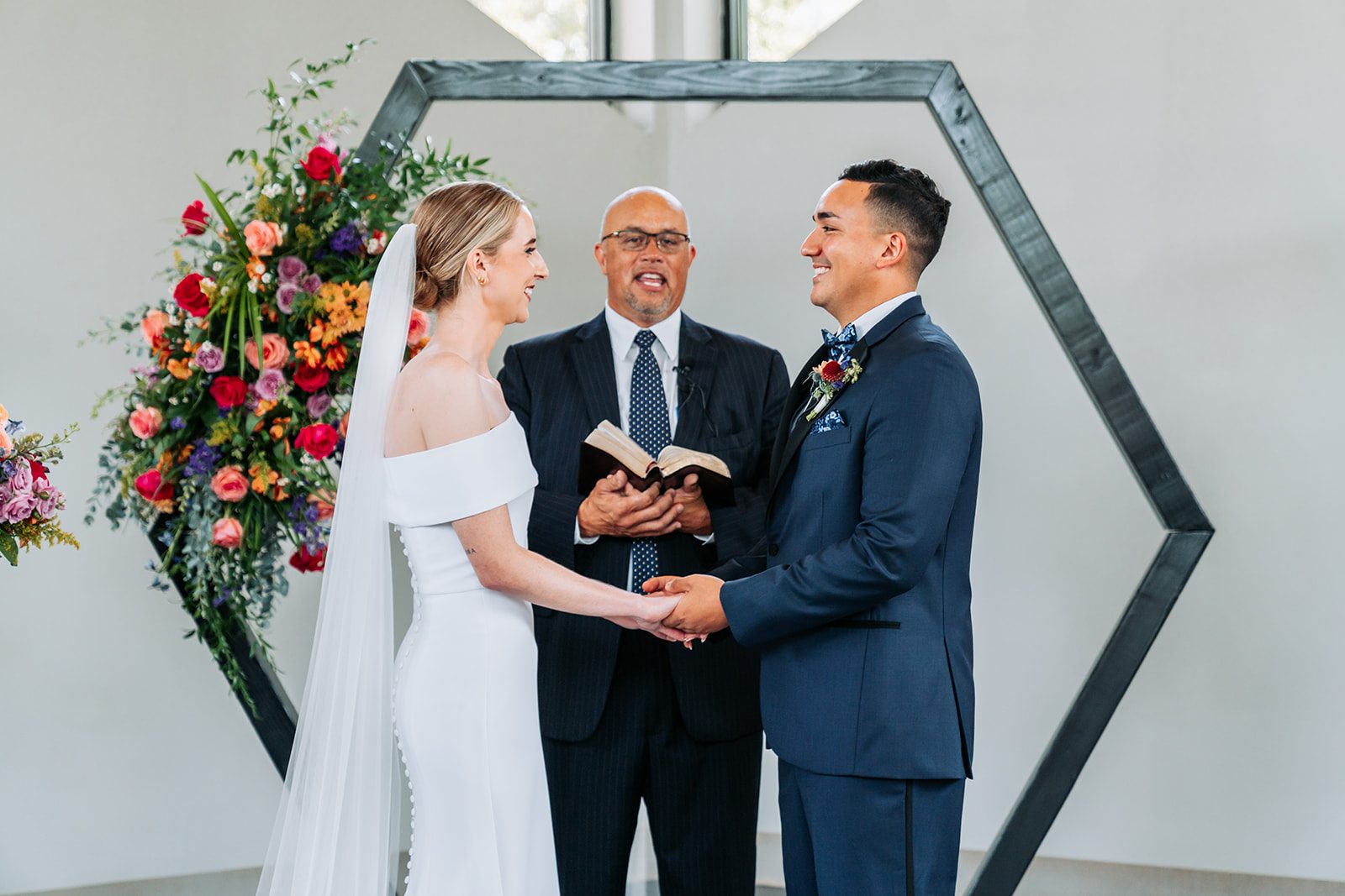 Sara and Gus exchanging vows at the altar